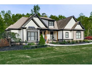 Charming home showcasing a well-maintained lawn, tasteful landscaping, and attractive contrasting trim details at 1076 Pinyan Ln, Canton, GA 30115