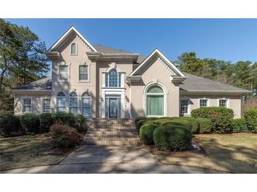 Charming two-story home with arched windows, complemented by mature landscaping and a welcoming entrance at 2009 Pine Forest Ct, Jonesboro, GA 30236