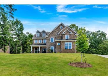 Beautiful brick two-story home featuring dormer windows and a well manicured lawn at 7474 Waterview Cv, Douglasville, GA 30135
