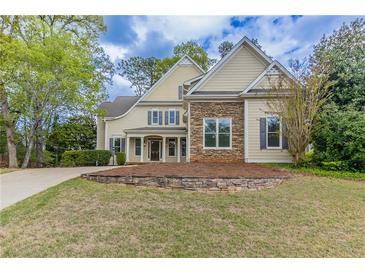 Charming two-story home featuring stone accents and a well-manicured lawn at 1209 Fenmore Hall Dr, Powder Springs, GA 30127
