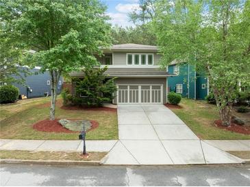 Charming two-story home with a well-manicured lawn, mature trees, and a driveway leading to a two-car garage at 1765 Stoney Creek Se Dr, Atlanta, GA 30316