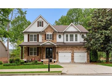 Charming two-story home with stone accents, well-manicured lawn, and a two-car garage at 5106 Davis Love Dr, Cumming, GA 30041