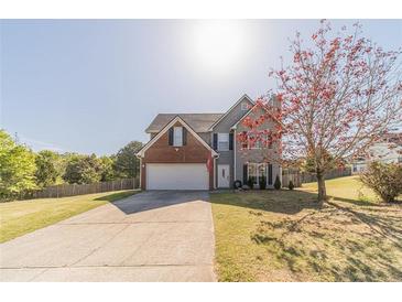 Charming two-story home with a well-manicured lawn and mature tree in a suburban neighborhood at 1542 Armende Cir, Dacula, GA 30019