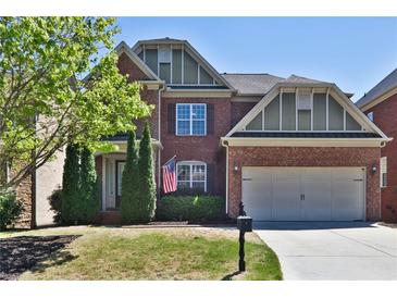Charming two-story brick home with a manicured lawn and two-car garage on a sunny day at 2248 Fort Se Dr, Smyrna, GA 30080