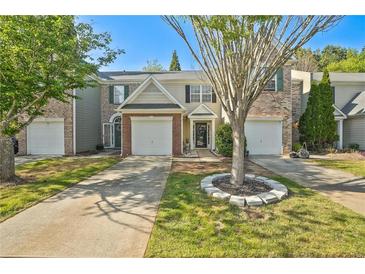 Charming townhome featuring a well-maintained lawn and an attached one-car garage at 384 Parc River Blvd, Lawrenceville, GA 30046