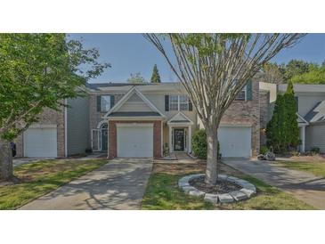Charming townhome featuring a one-car garage, manicured lawn, and welcoming entrance at 384 Parc River Blvd, Lawrenceville, GA 30046