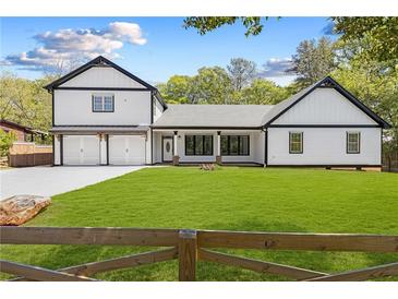 Charming two-story home with black trim, white siding, two-car garage and expansive front lawn at 915 John Ward Rd, Marietta, GA 30064