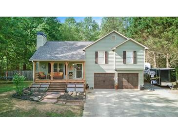 Charming home with a covered porch and well-maintained landscaping on a wooded lot at 655 Poplar Rd, Dallas, GA 30157