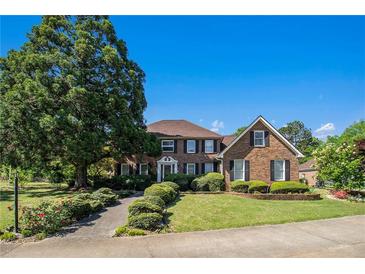 Charming two-story brick home featuring a well-manicured lawn and mature landscaping at 2405 Old Salem Se Rd, Conyers, GA 30013