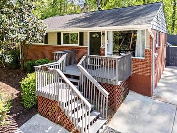 Inviting single-story home with brick facade, charming elevated porch, and well-maintained landscaping at 1211 Argonne Ne Way, Atlanta, GA 30324