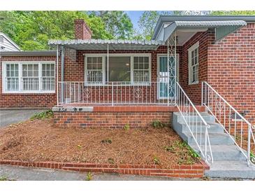 Charming red brick house with a cozy covered porch and decorative white railing at 1766 Sw Brewer Sw Blvd, Atlanta, GA 30310