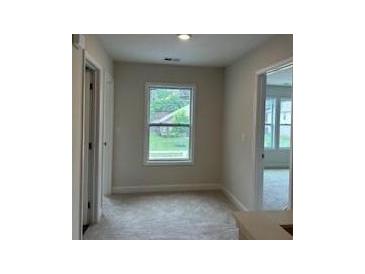 Bright hallway featuring natural light from a window, complemented by neutral walls and carpet at 3536 Dogwood Pass, Stonecrest, GA 30038
