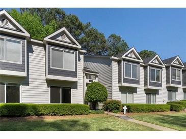 Exterior view of townhomes with gray and white siding, decorative windows, and well-maintained landscaping at 111 Fair Haven Se Way, Smyrna, GA 30080