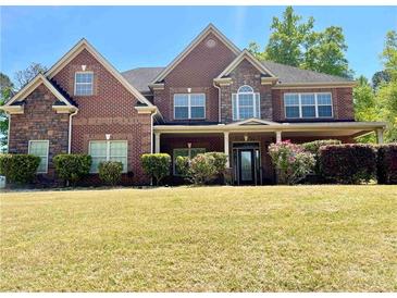 Beautiful brick home with stone accents, covered front porch, manicured hedges, and a well-kept lawn at 220 Fannin Ln, Mcdonough, GA 30252