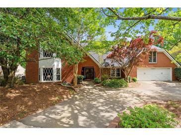 Charming red brick home with lush landscaping and a welcoming driveway at 4820 Coppedge Trl, Peachtree Corners, GA 30096