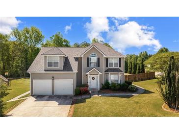 Charming two-story home with a well-manicured lawn and two-car garage at 6955 Pompas Ct, Douglasville, GA 30135