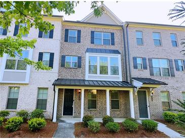 Charming brick townhouse with a covered entrance and well-maintained landscaping at 2102 Talmai Dr, Snellville, GA 30078