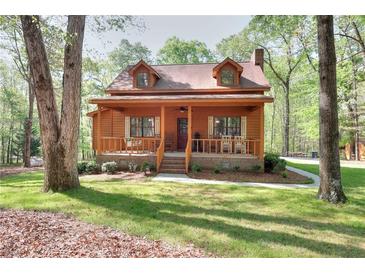 Charming cabin home featuring dormer windows and a welcoming front porch with seating at 2435 Farmer Road, Conyers, GA 30012