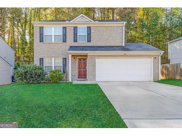 Charming two-story brick home featuring a well-manicured lawn and an attached two-car garage at 5622 Laurel Ridge Dr, East Point, GA 30344