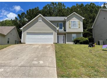 Charming two-story home featuring a well-maintained lawn and a concrete driveway leading to an attached two-car garage at 1421 Isleworth Cir, College Park, GA 30349