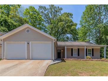 Charming single-story home with a two-car garage, well-maintained lawn and beautiful landscaping with plenty of mature trees at 1363 To Lani Farm Rd, Stone Mountain, GA 30083
