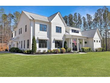 Charming two-story white home featuring black-framed windows, landscaped yard, and American flag at 1455 Rucker Cir, Woodstock, GA 30188
