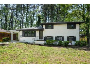 Charming, renovated home featuring a classic white painted brick exterior and mature trees at 3031 San Jose Dr, Decatur, GA 30032