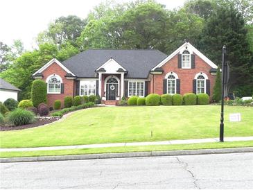 Charming brick home with a beautifully landscaped front yard and lush green lawn at 4019 Hickory Fairway Dr, Woodstock, GA 30188