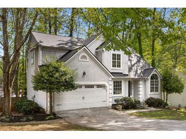 Charming home featuring a two-car garage and a well-manicured lawn at 1200 Taylor Oaks Dr, Roswell, GA 30076