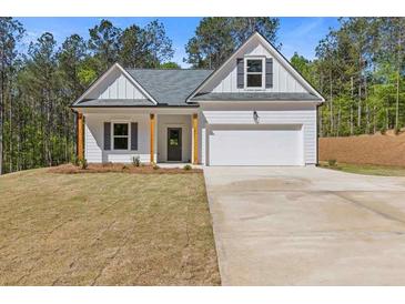 Charming one-story home featuring a two-car garage, a welcoming front porch, and a well-maintained lawn at 1408 Campbell Rd, Covington, GA 30014