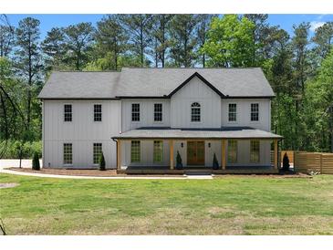 Charming two-story home with a welcoming front porch and manicured lawn at 3984 Earney Rd, Woodstock, GA 30188
