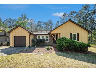 Charming ranch-style home featuring a stone accent, manicured lawn and attached garage at 8083 Cypress Ct, Villa Rica, GA 30180