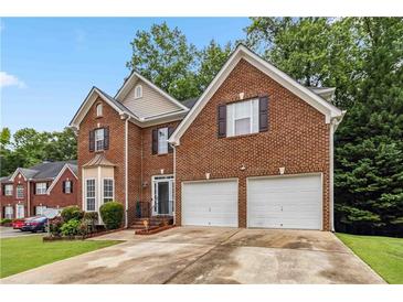 Charming brick home featuring a two-car garage and well-maintained landscaping at 3215 Rose Petal Ln, Powder Springs, GA 30127
