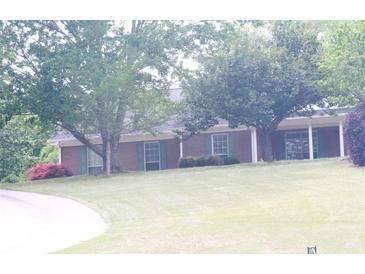 Charming single-story brick home with lush green lawn and mature trees at 4045 Fawn Valley Dr, Loganville, GA 30052