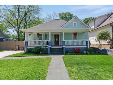 Charming home featuring a welcoming front porch, lush landscaping, and a well-manicured lawn at 1292 Eubanks Ave, Atlanta, GA 30344