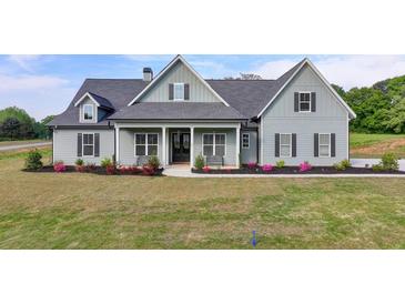 Charming single-Gathering home featuring a well-manicured lawn and a welcoming covered front porch with stylish finishes at 86 Ewing Way, Dacula, GA 30019