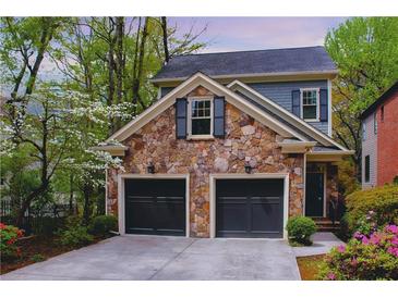 Charming two-story home featuring stone accents, a two-car garage, and professionally landscaped yard at 1048 Standard Ne Dr, Brookhaven, GA 30319