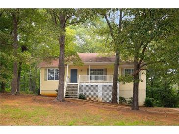 Charming yellow home with a cozy front porch and lush green trees surrounding the property at 21 Misty Hollow Ct, Euharlee, GA 30145