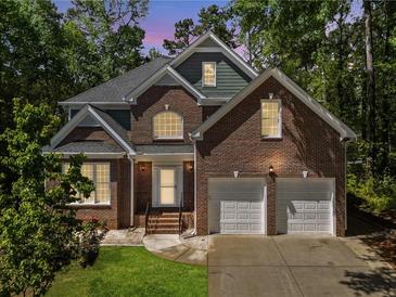 Traditional brick home featuring an attached two-car garage and professionally landscaped front yard at 225 Bayswater Dr, Suwanee, GA 30024
