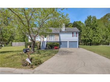 Charming two-story home with a well-maintained front yard and a two-car garage on a sunny day at 582 Linda Ln, Powder Springs, GA 30127