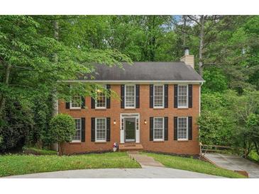 Charming two-story brick home with black shutters surrounded by lush landscaping at 2895 Shurburne Dr, Alpharetta, GA 30022