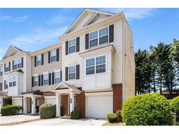 Inviting three-story townhome showcasing a charming exterior with a one-car garage and well-maintained landscaping at 2419 Ivey Crest Cir, Tucker, GA 30084
