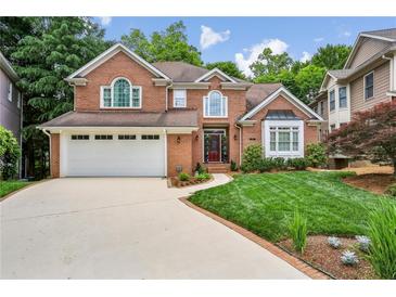 Charming two-story brick home with manicured lawn, attached garage, and inviting curb appeal at 1016 Lenox Ne Crst, Atlanta, GA 30324