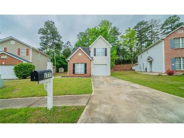Charming two-story home with brick and vinyl siding, well-maintained lawn, and a private driveway at 3777 Oakland Spring Ct, Snellville, GA 30039