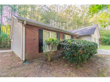 Brick and vinyl exterior with trimmed windows and manicured landscaping at 3856 Vine Stone Dr, Lithonia, GA 30038