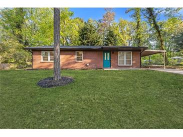 Charming brick ranch-style home with a well-maintained lawn and a bright blue front door at 622 Saddlewood Dr, Lawrenceville, GA 30043