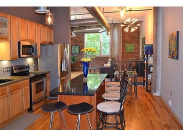 Modern kitchen featuring stainless steel appliances, wooden cabinets, and an island with barstool seating at 172 Haynes Sw St # 107, Atlanta, GA 30313