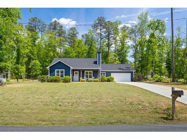Charming blue home with a well-manicured lawn and attached garage, perfect for suburban living at 60 Water Oak Trl, Covington, GA 30014