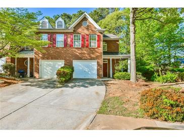 Charming two-story brick home with red shutters, a well-manicured lawn, and a two-car garage at 6125 Brookechase Ln, Norcross, GA 30093