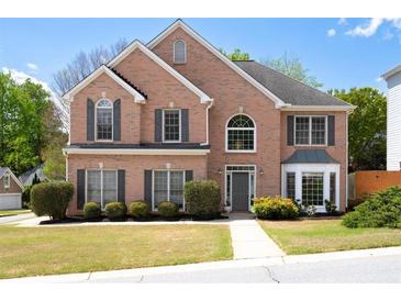 Charming two-story brick home with manicured landscaping, gray shutters, and a welcoming entrance at 5395 Fontenoy Ct, Peachtree Corners, GA 30071